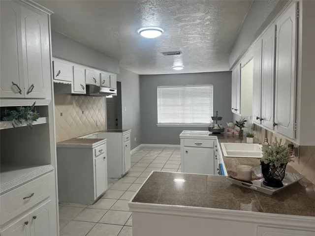 a kitchen with a sink cabinets and window