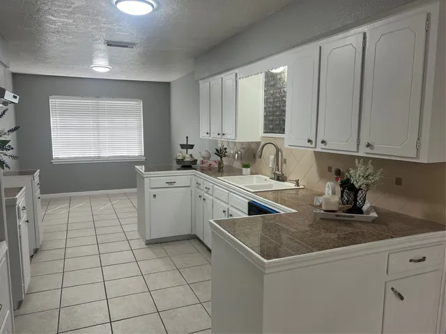 a kitchen with a stove sink and cabinets