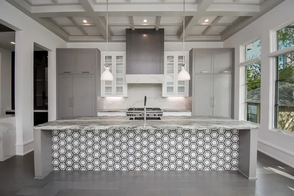 a kitchen with kitchen island granite countertop a stove a sink and a granite counter tops