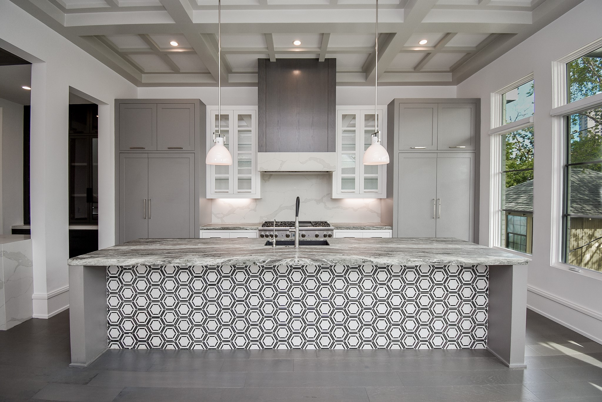 a kitchen with kitchen island granite countertop a stove a sink and a granite counter tops