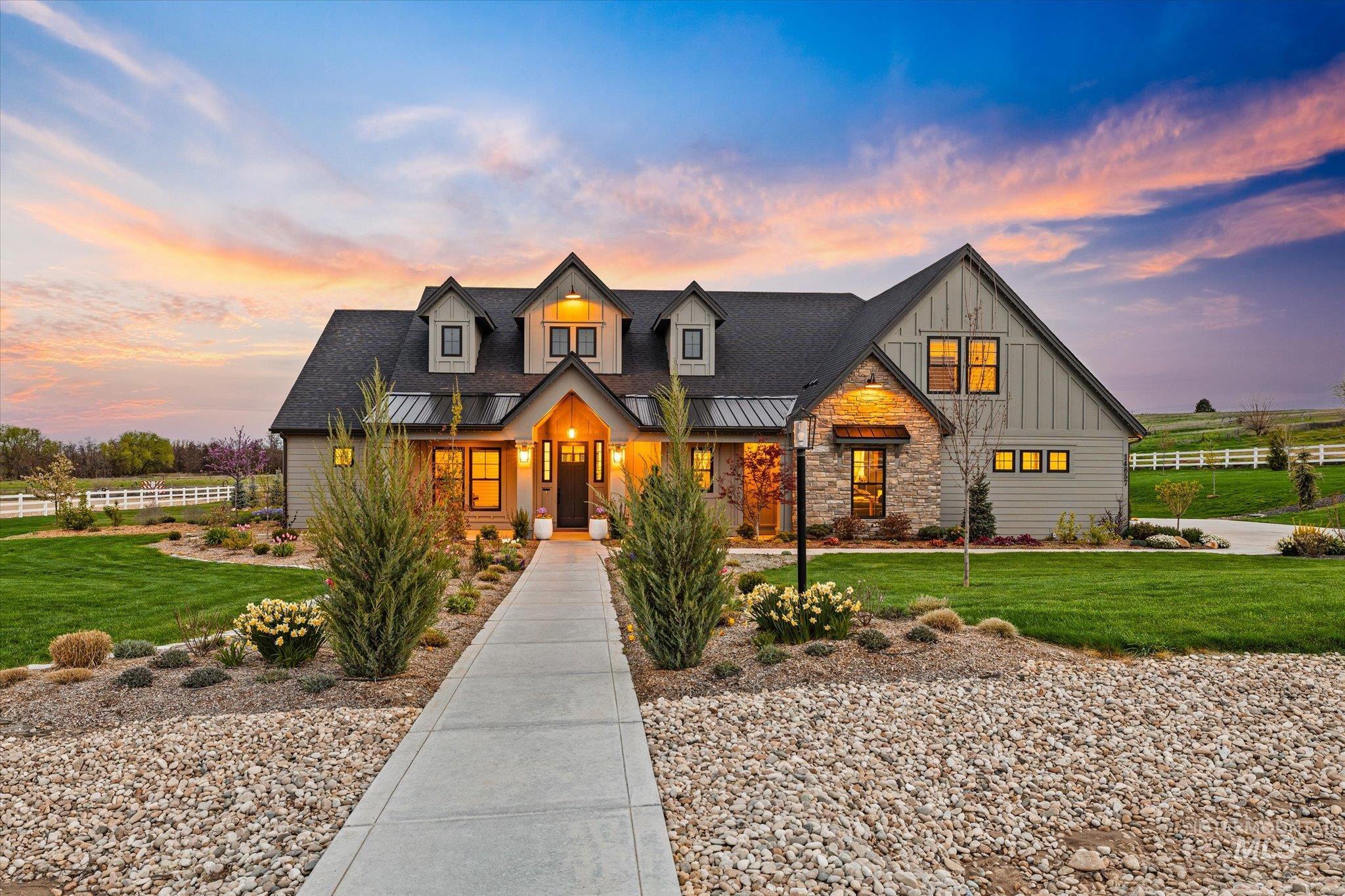Modern inspired farmhouse with stone siding, board and batten siding, covered porch, and a standing seam roof
