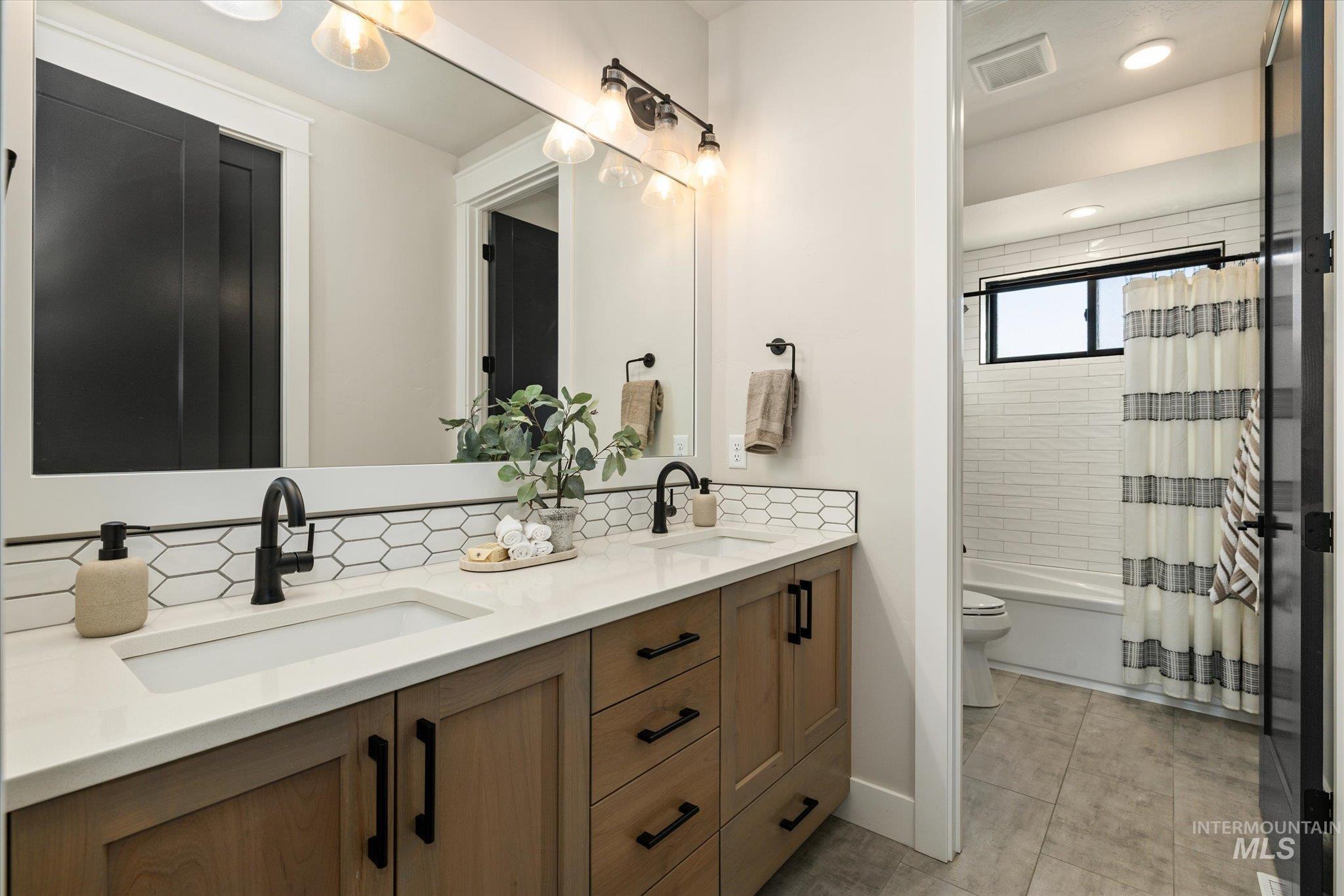 14857 Elk Spg Street Caldwell, ID 83607 - Photo 22 of 40 Bathroom with double vanity, shower / bath combo with shower curtain, and recessed lighting