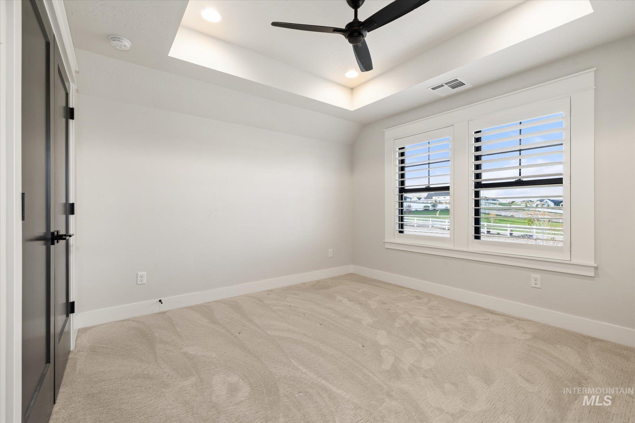 14857 Elk Spg Street Caldwell, ID 83607 - Photo 27 of 40 Empty room with light colored carpet, ceiling fan, recessed lighting, and a raised ceiling