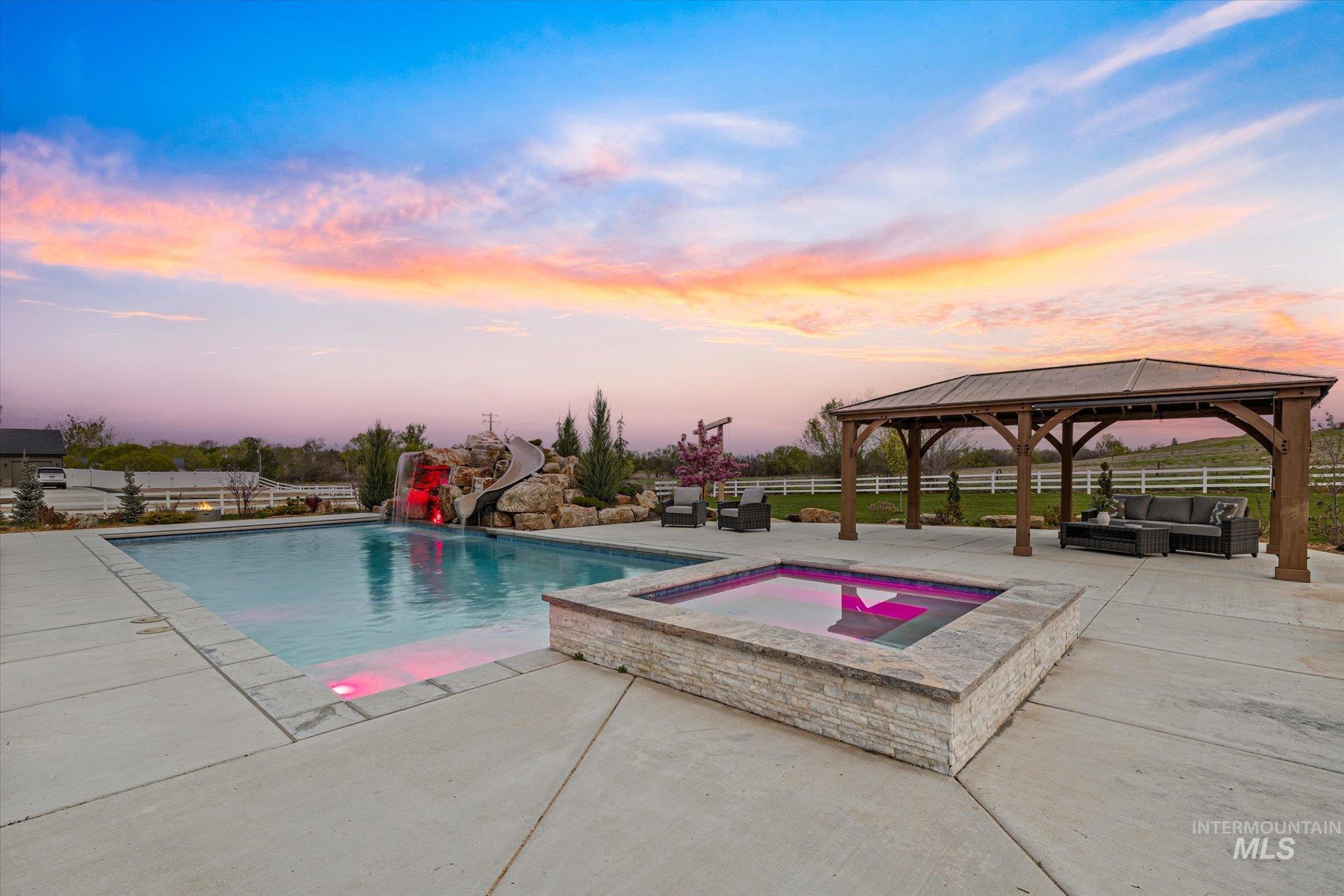14857 Elk Spg Street Caldwell, ID 83607 - Photo 5 of 40 View of pool featuring an in-ground hot tub, a water slide, patio surround, a gazebo, and a fenced backyard