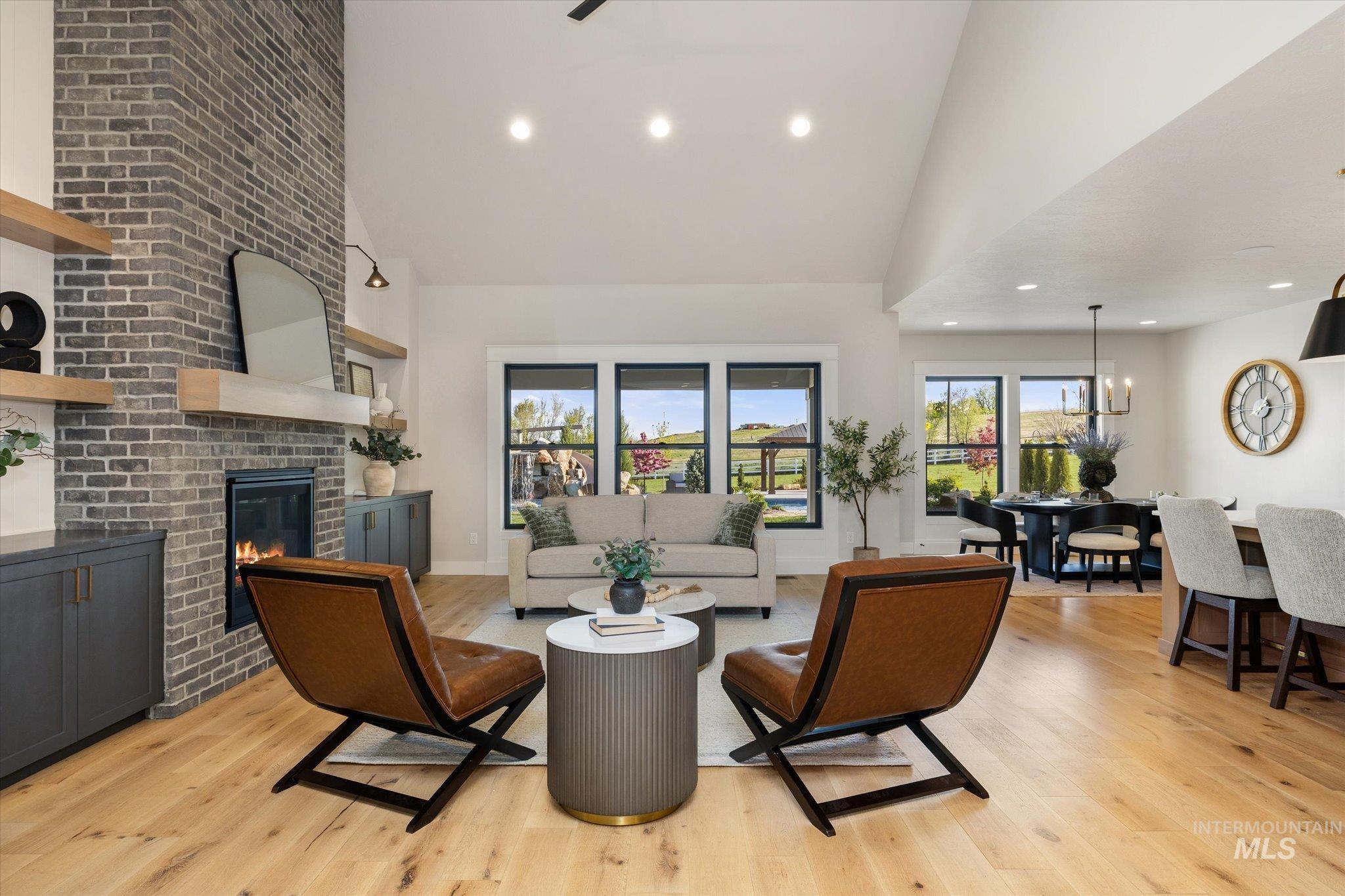 14857 Elk Spg Street Caldwell, ID 83607 - Photo 8 of 40 Living room with a fireplace, vaulted ceiling, light wood-style flooring, suspended lighting, and a ceiling fan