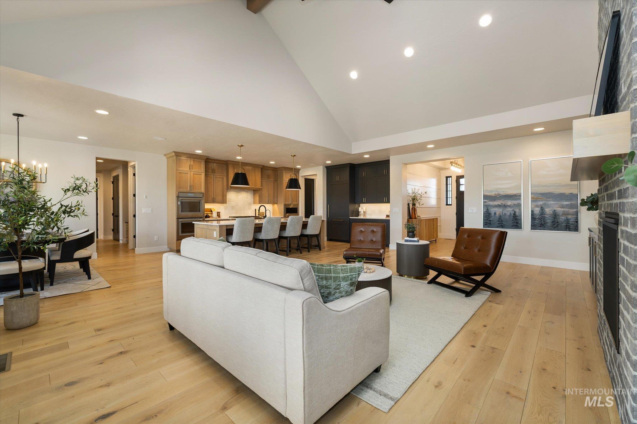 14857 Elk Spg Street Caldwell, ID 83607 - Photo 10 of 40 Living area with a stone fireplace, light wood finished floors, and a chandelier