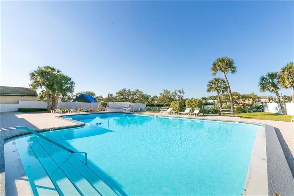 4758 Jasper Drive, Unit 206 New Port Richey, FL 34652 - Photo 18 of 34 a view of a swimming pool and lounge chair