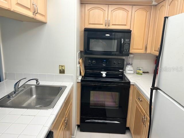 4758 Jasper Drive, Unit 206 New Port Richey, FL 34652 - Photo 4 of 34 a kitchen with a stove microwave and sink