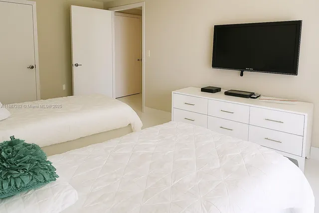 a bedroom with two beds and painting on the wall