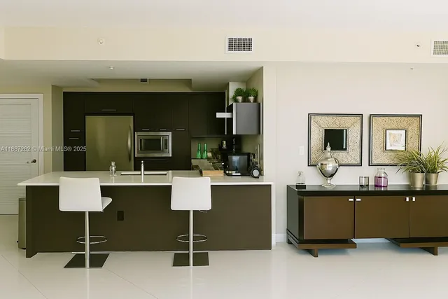 a living room with couches chairs and kitchen view