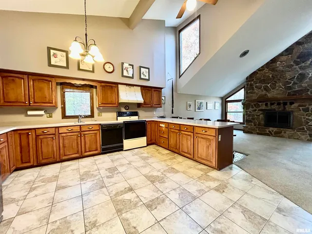 a large kitchen with stainless steel appliances granite countertop a stove sink and cabinets
