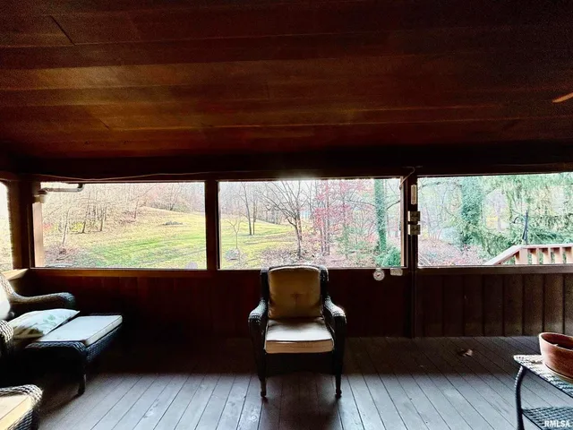 a living room with large windows and a table