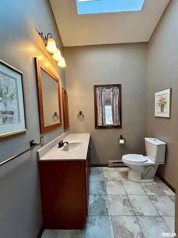 a bathroom with a toilet a sink and mirror