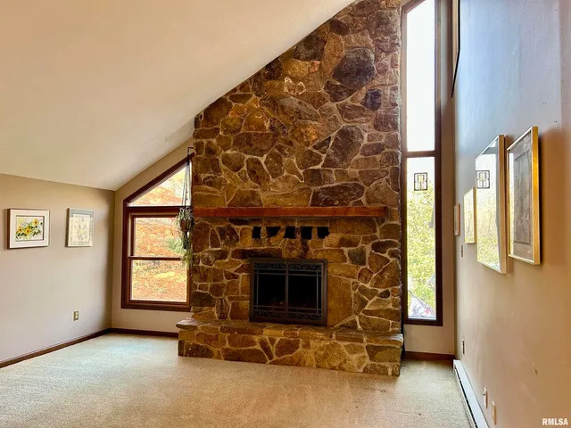 a view of an empty room with a fireplace and a window