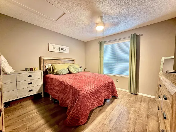 a bedroom with a bed and a flat tv screen on dresser