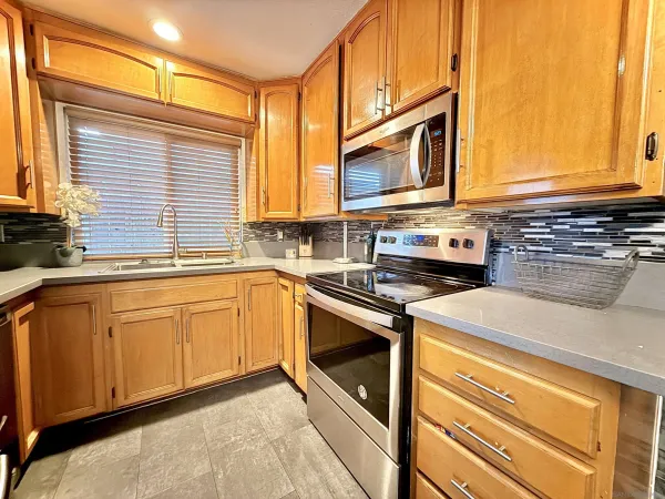 a kitchen with stainless steel appliances granite countertop a sink a stove and a microwave
