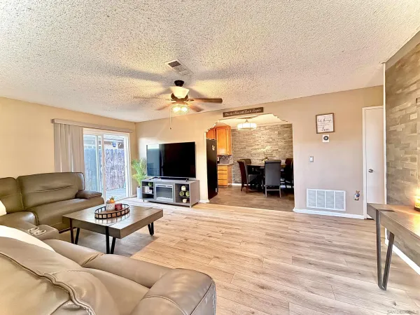 a living room with furniture a flat screen tv and a fireplace