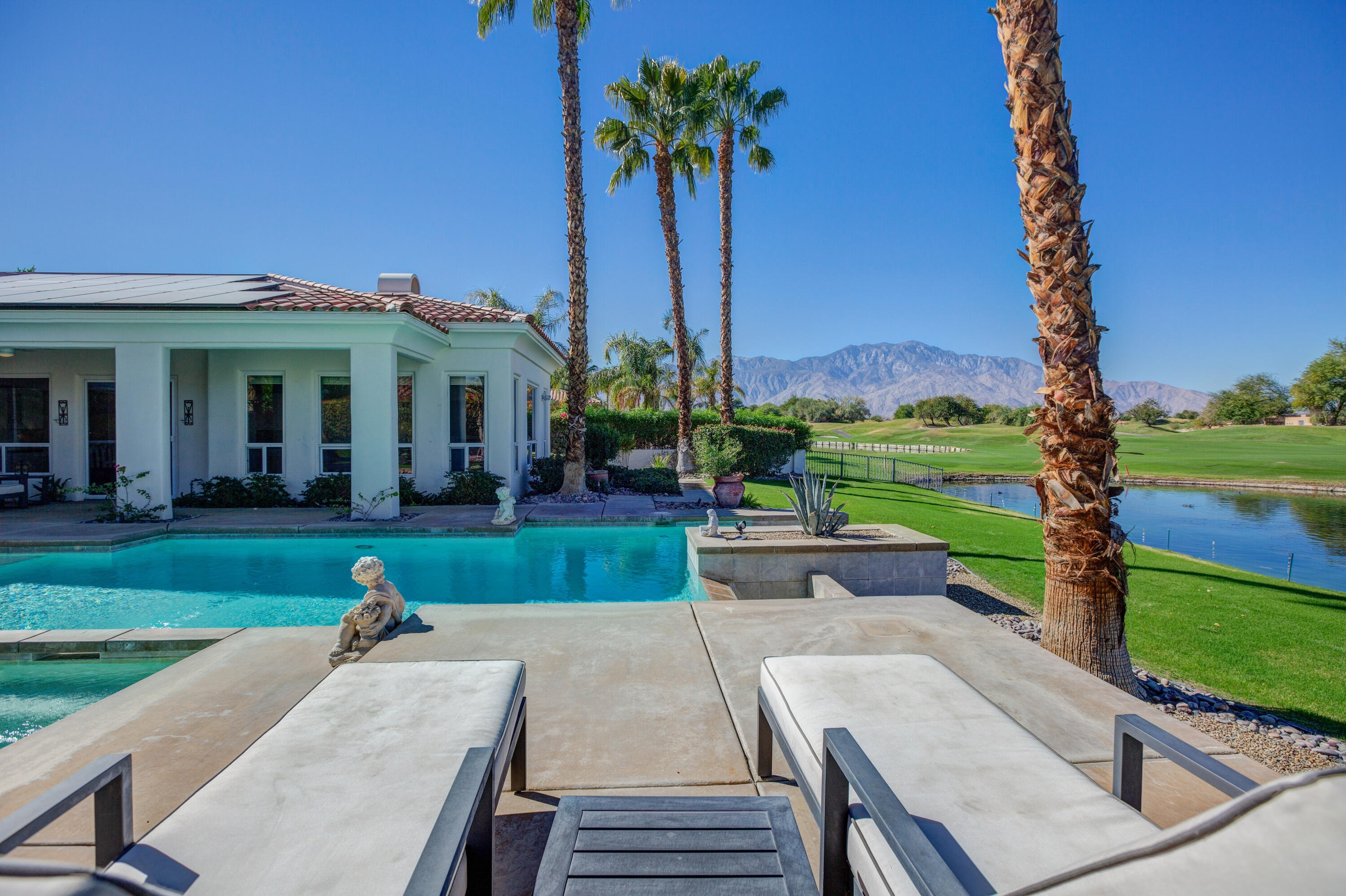 390 Loch Lomond Road Rancho Mirage, CA 92270 - Photo 1 of 55 a view of a house with a yard and sitting area