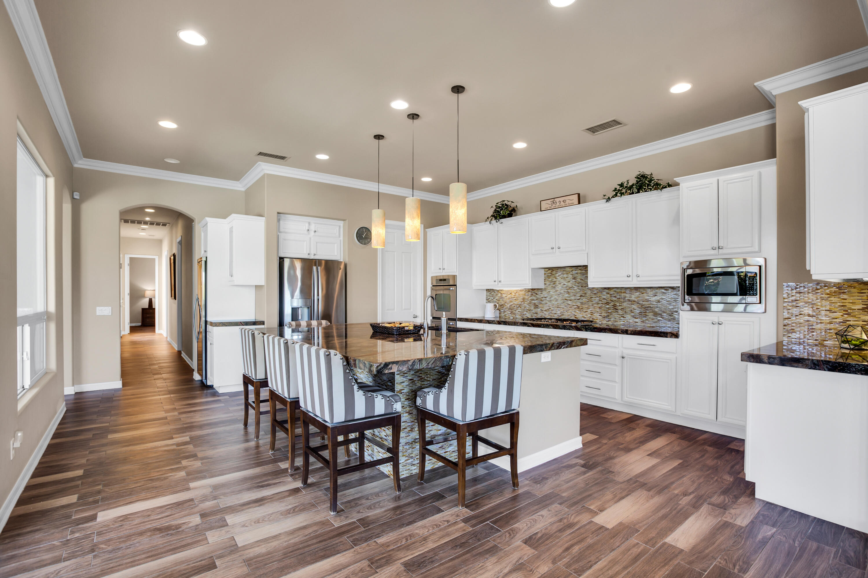390 Loch Lomond Road Rancho Mirage, CA 92270 - Photo 15 of 55 a kitchen with stainless steel appliances a dining table chairs microwave and cabinets