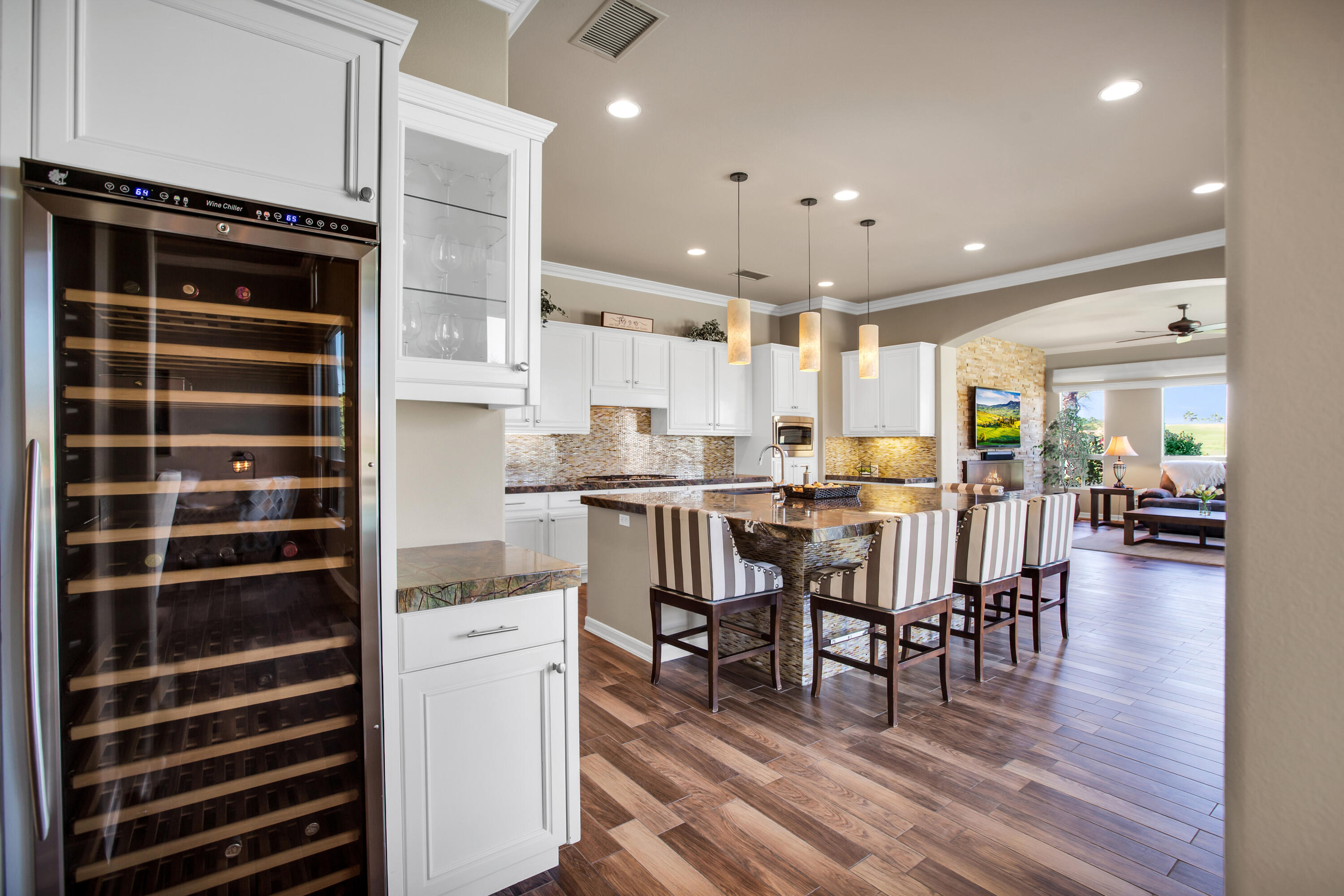 390 Loch Lomond Road Rancho Mirage, CA 92270 - Photo 19 of 55 a kitchen with stainless steel appliances kitchen island granite countertop a refrigerator a stove a dining table and chairs with wooden floor