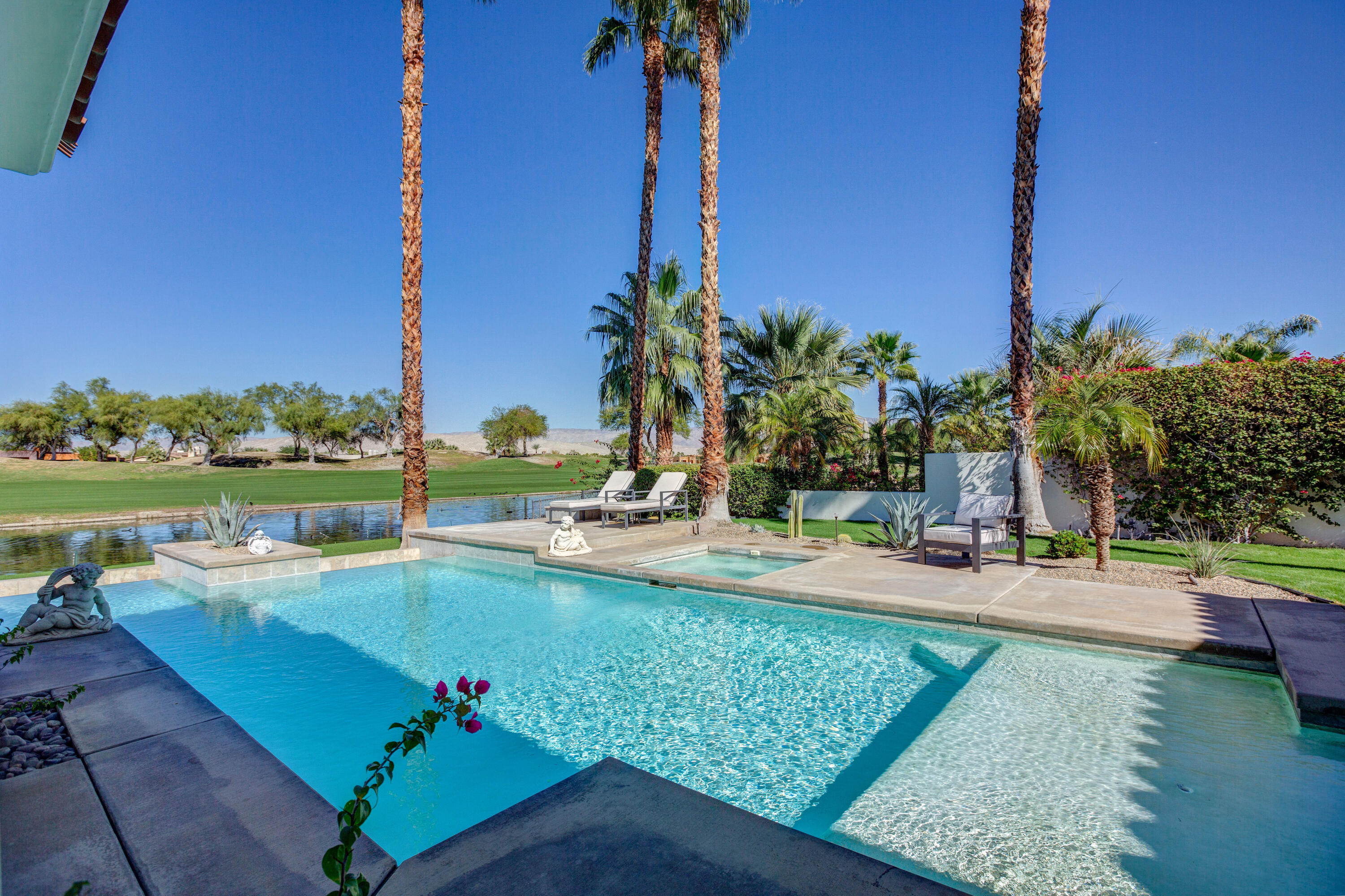 390 Loch Lomond Road Rancho Mirage, CA 92270 - Photo 3 of 55 a view of a swimming pool with a lawn chairs and a table