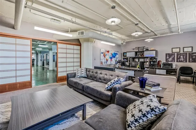 a living room with furniture and a ceiling fan