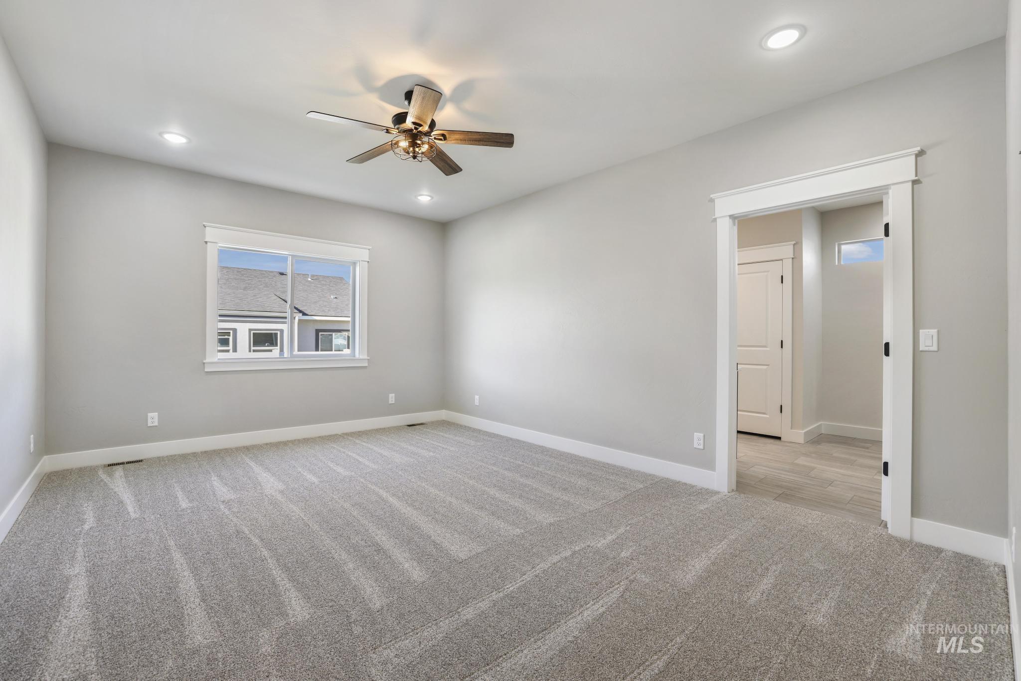 298 Sandi Road Twin Falls, ID 83301 - Photo 13 of 24 Spacious room featuring neutral carpeting, a modern ceiling fan, recessed lighting, and a large window with white trim