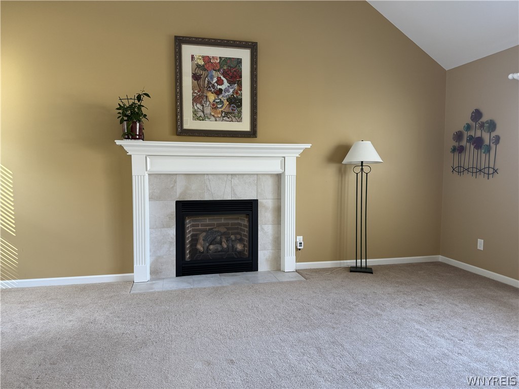 73 Chestnut Lancaster, NY 14086 - Photo 9 of 41 A classic tiled fireplace anchors the main wall beneath a soaring vaulted ceiling.