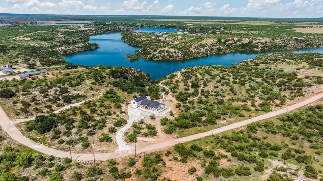 an aerial view of residential houses with outdoor space and trees