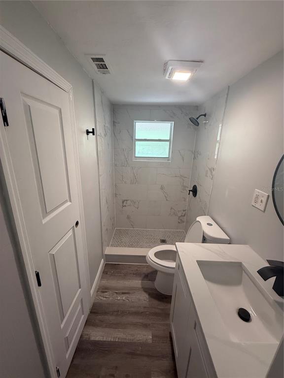 9029 Maiden Lane Aripeka, FL 34679 - Photo 3 of 11 a bathroom with a sink a toilet and shower