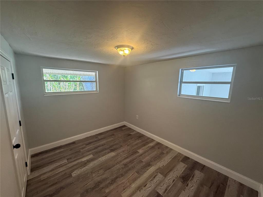 9029 Maiden Lane Aripeka, FL 34679 - Photo 4 of 11 a view of room with hardwood floor and window