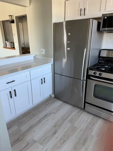 a kitchen with stainless steel appliances granite countertop a refrigerator a stove and a sink