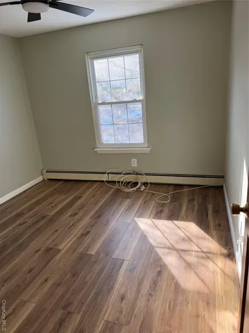 a view of a room with wooden floor and a window