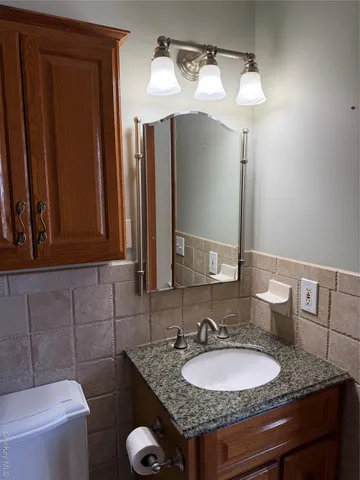 a bathroom with a granite countertop sink and a mirror