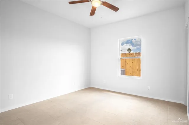 an empty room with a window and ceiling fan