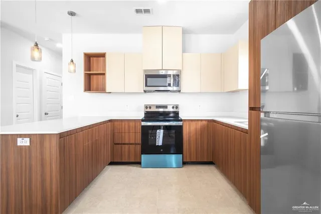 a kitchen with stainless steel appliances a stove a sink and a microwave