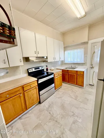 a kitchen with stainless steel appliances a stove a sink and a refrigerator