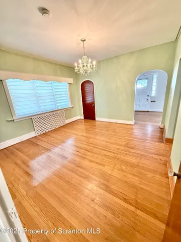 a view of a room with wooden floor and a potted plant