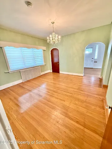 a view of a room with wooden floor and ceiling fan