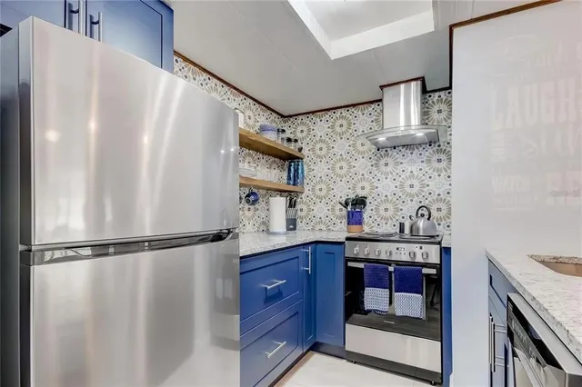 a kitchen with stainless steel appliances granite countertop a refrigerator and a sink
