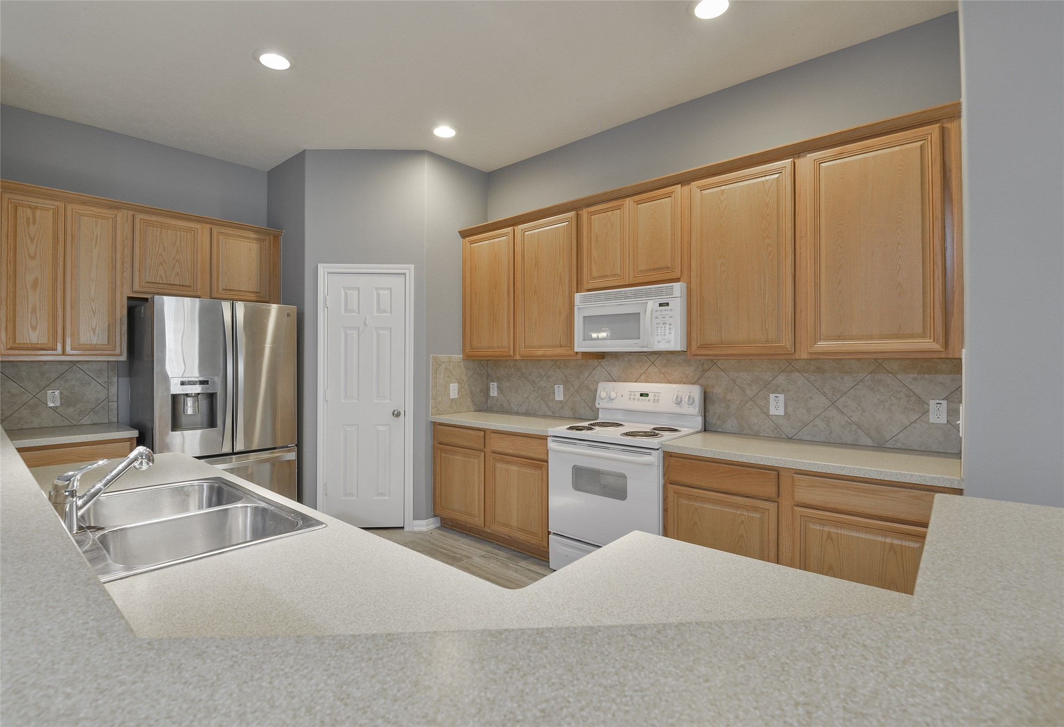 18411 Atasca Wds Trace Humble, TX 77346 - Photo 13 of 39 a kitchen with granite countertop a refrigerator stove top oven and sink