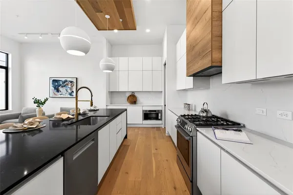 a kitchen with granite countertop a sink a stove and cabinets