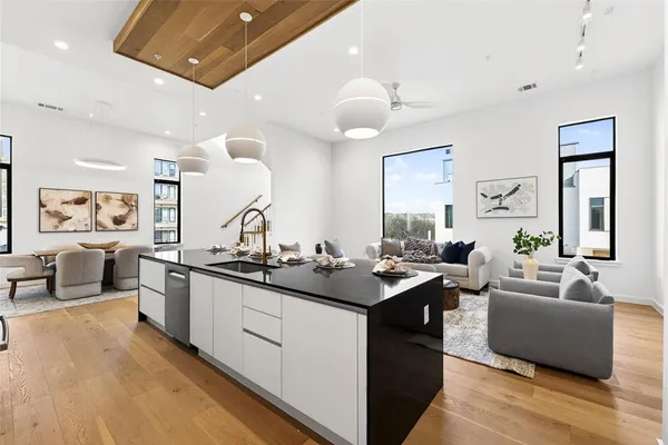 a kitchen with counter top space sink stove and wooden floor