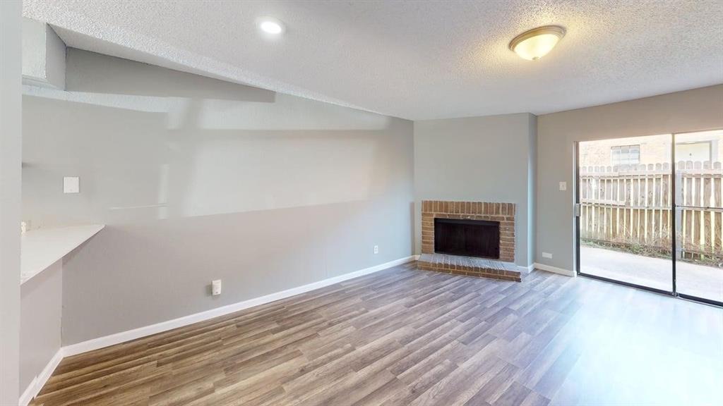 8108 Foxfire Lane, Unit B White Settlement, TX 76108 - Photo 10 of 12 wooden floor in an empty room with a fireplace
