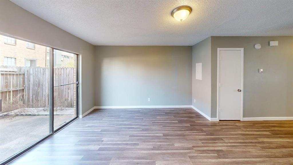 8108 Foxfire Lane, Unit B White Settlement, TX 76108 - Photo 8 of 12 a view of an empty room with wooden floor and a window