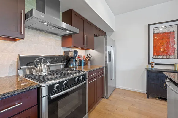 a kitchen with stainless steel appliances granite countertop a stove and a refrigerator