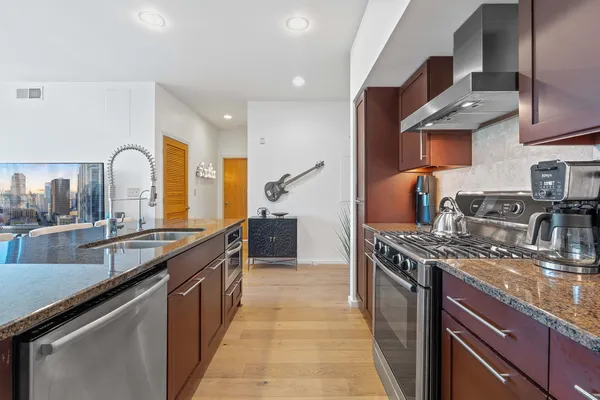 a kitchen with stainless steel appliances granite countertop a sink and stove