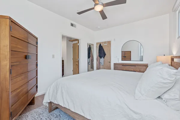 a bedroom with a bed and a dresser with mirror