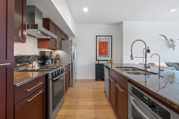 a kitchen with stainless steel appliances granite countertop a sink and cabinets