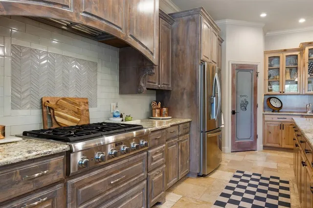 a kitchen with stainless steel appliances granite countertop a stove a sink and a refrigerator
